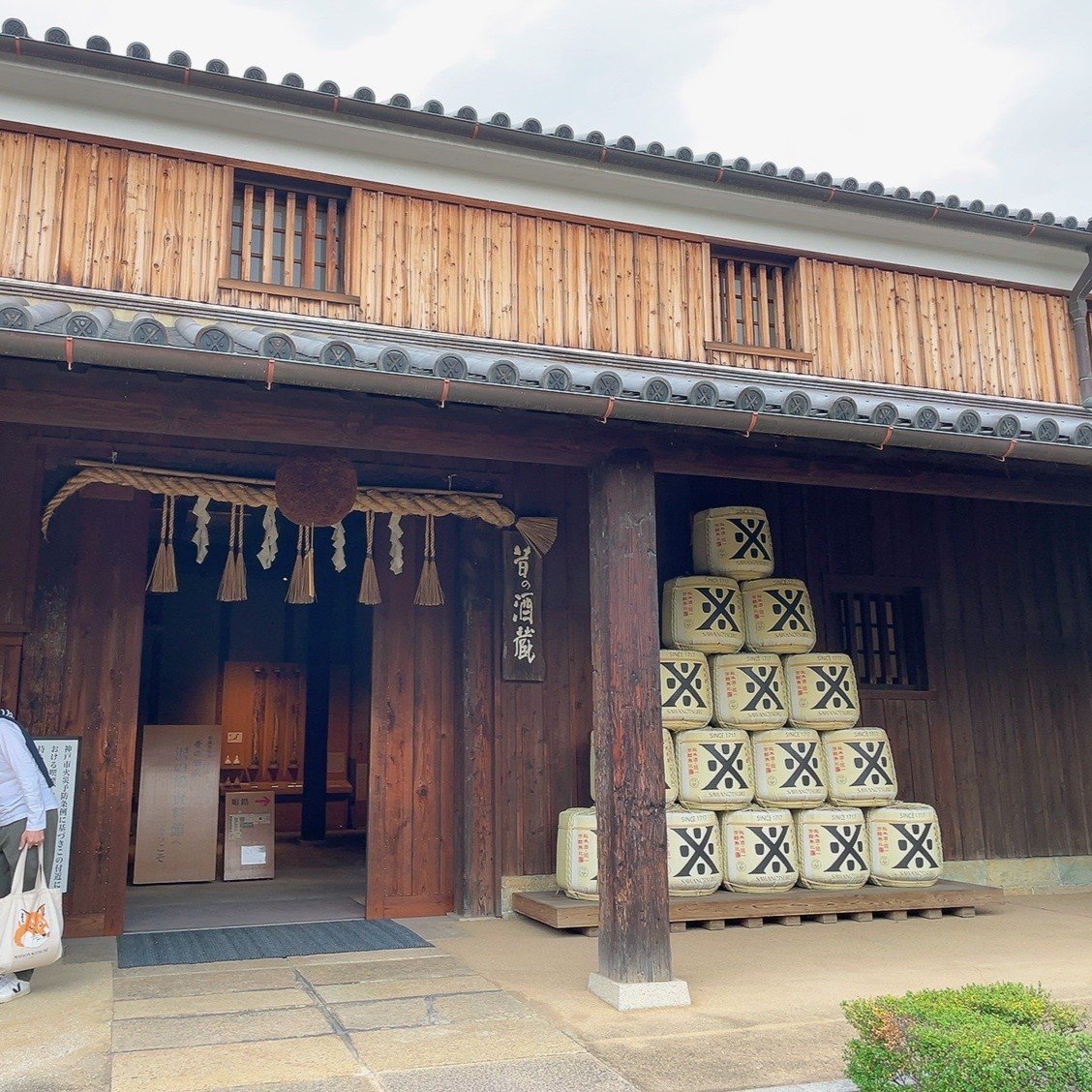 杉玉としめ縄が掛かる「昔の酒蔵」の入口と、「SINCE 1717」の菰樽が積まれた様子