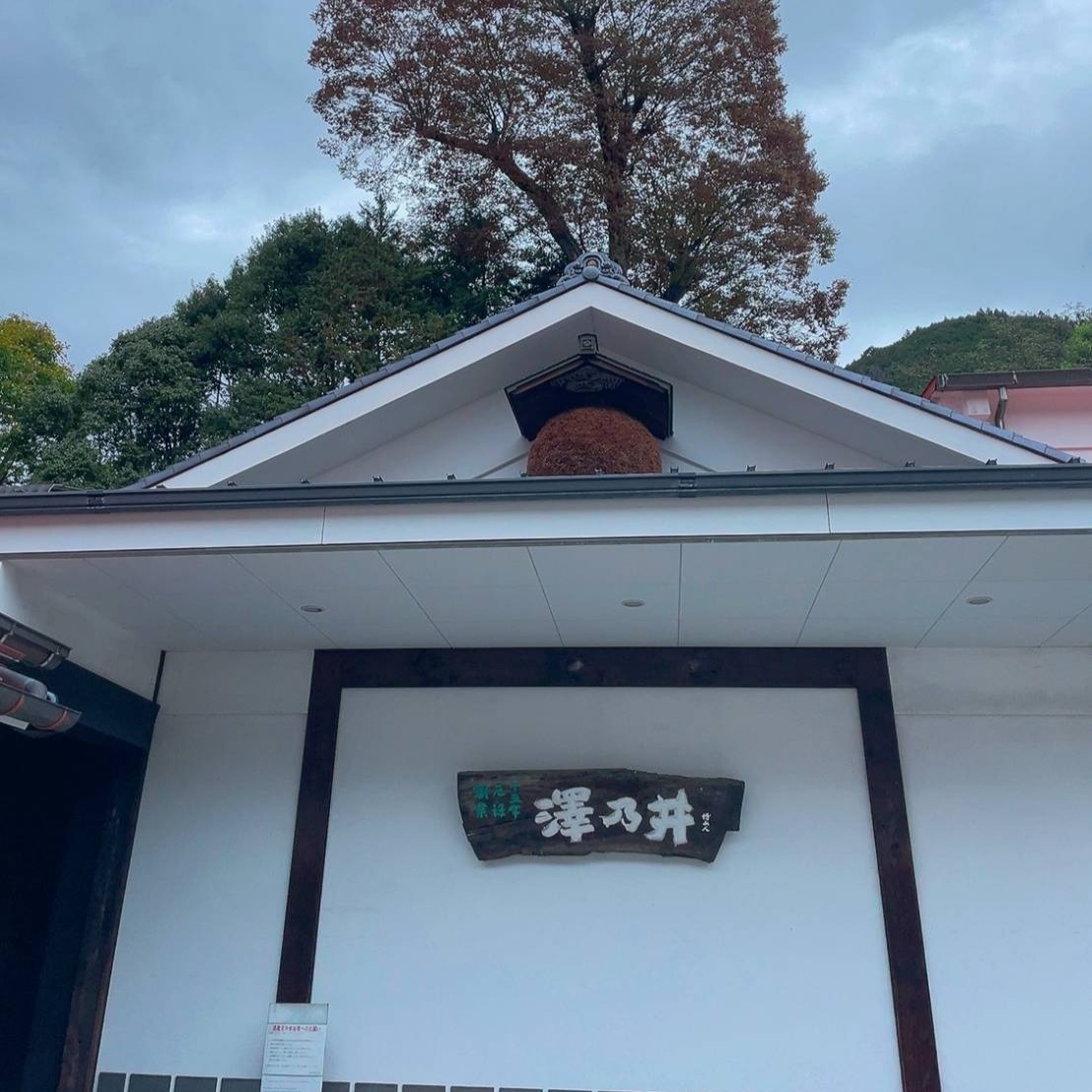 破風に杉玉が掛かる蔵の建物と、「澤乃井」の木の看板